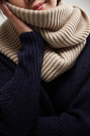 Frage, ob Kaschmir kratzt: Modell mit beigem Rippschal am Hals und dunkelblauem Strickpullover, Detailansicht
