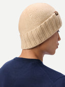 Rückansicht der beigen Strickmütze mit Umschlag und kleinem Lederlabel am Rand