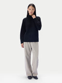 Ganzkörperaufnahme des schwarzen Pullovers kombiniert mit beiger weiter Hose und schwarzen Schuhen