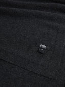 Detailansicht der Charcoal Decke mit feiner Strickstruktur, Kante und eingenähtem GOBI Label