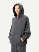 Unisex Kaschmir Kapuzenpullover in Plum Kitten, am Model getragen, Kapuze auf, Hände in der Kängurutasche