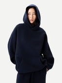 Unisex Kaschmir Kapuzenpullover in India Ink, getragen mit aufgesetzter Kapuze, Vorderansicht mit Kängurutasche
