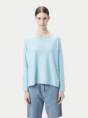 Modell trägt den aquamarinfarbenen Strickpullover zu hellen Jeans, Oberkörper von vorn