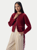Modell in Damen Kaschmir Strickjacke in Chili Red mit geflochtenen Borten, Halbprofil vorne