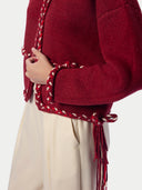 Nahaufnahme von Saum, Ärmelbündchen und Fransen der Flechtbänder in Chili Red