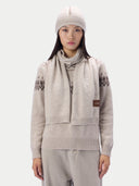 Modell trägt den beigen Schal lose über dem gemusterten Pullover, Vorderansicht mit Mütze