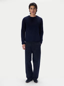 Ganzkörperansicht des Modells im navyfarbenen Pullover zu dunkler Hose und Loafern