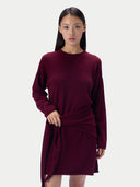 Modell in Wine Red, locker fallender Strick mit asymmetrisch drapierten Falten über der Hüfte