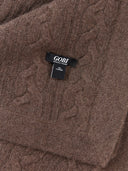 Detailaufnahme des Zopfstrickmusters in Braun mit eingenähtem Label 100% Cashmere
