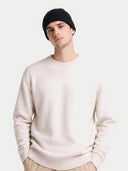 Gerippte Beanie aus Kaschmir in Schwarz mit umgeschlagenem Bund, von einem Model zu hellem Pullover getragen, Vorderansicht