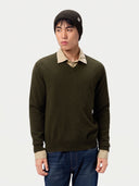 Model trägt die gerippte Mütze in Olive Brown zu V-Ausschnitt-Pullover, Hemd und Jeans