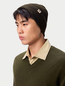 Seitenansicht der Strickmütze in Olive Brown am Model mit breitem Umschlag und Etikett