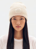 Model trägt Damen Kaschmirmütze in Marshmallow mit Rippstruktur, Umschlag und Ton-in-Ton-Stickdetail, Vorderansicht