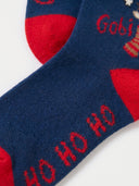 Nahaufnahme der Gobi Kaschmirsocken für Weihnachten in Deep Cobalt, rote Ferse und HO HO HO Schriftzug