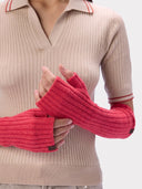 Nahaufnahme der Rippstrick-Handwärmer in Bright Red mit gefasster Daumenöffnung, am Model getragen