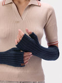 Detailansicht der navyblauen Armstulpen mit Daumenöffnung und Rippenstruktur, getragen zu einem beigen Polo