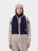Modell trägt den Navy-Schal lose um den Hals über dem gemusterten Pullover, Vorderansicht mit Mütze
