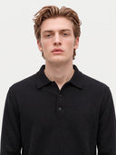 Nahaufnahme von spitzem Kragen und kurzer Knopfleiste des schwarzen Polostrickpullovers am Model