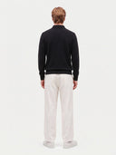 Rückansicht des schwarzen Polostrickpullovers mit glatter Strickfläche und Rippsaum