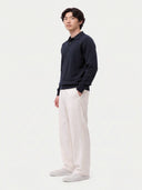 Seitenansicht des navyfarbenen Polostrickpullovers mit langen Ärmeln und Rippbündchen