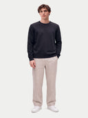 Feiner Kaschmirpullover mit Rundhalsausschnitt in Navy, von einem Model getragen, Vorderansicht mit beiger Hose