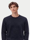 Nahaufnahme des navyfarbenen Pullovers mit geripptem Rundhals und glattem Jersey-Strick am Model