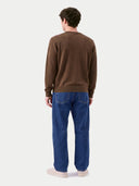 Rückansicht des leichten Strickpullovers in Dark Brown, von einem Model zu blauer Jeans getragen