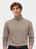 Nahaufnahme des Pullovers in Taupe mit hohem Umschlagkragen und Rippbündchen, am Model getragen