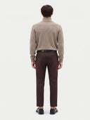 Rückansicht des Pullovers in Taupe mit Rollkragen und glattem Jersey-Strick, am Model getragen
