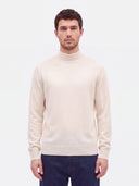Nahaufnahme des weißen Strickpullovers am Model, gerippter Halsabschluss und glatter Jersey-Strick