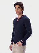 Kaschmir-Cricket-Pullover in Navy am Model, Dreiviertelansicht mit gestreiftem V-Ausschnitt und gestreiften Bündchen
