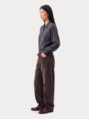 Seitenansicht des Strickpolos in Graphite Black, kombiniert mit brauner weiter Hose