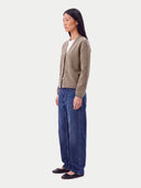 Seitenansicht der Kaschmir-Strickjacke in Taupe mit regulärer Passform, kombiniert mit Jeans und Ballerinas