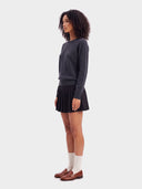 Model trägt den Navy Pullover zu schwarzem Minirock, Seitenansicht mit schmalen Bündchen