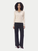 Model trägt den gerippten Cricket-Pullover in Pure White zu schwarzer weiter Jeans, Ganzkörperansicht