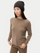 Model trägt die leichte Strickmütze in Olive Brown zu einem braunen Rundhalspullover