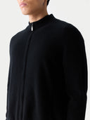 Detailaufnahme von Stehkragen und Reißverschlusszipper der schwarzen Strickjacke am Model