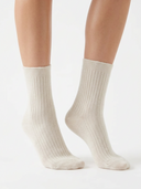Wadenhohe Kaschmirsocken im Rippstrick in Warm Light, an den Füßen eines Models getragen, Vorderansicht
