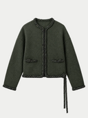 Damen Kaschmir Strickjacke in Ink Black mit handgeflochtenen Borten, geflochtenen Taschenpatten und seitlichem Bindeband, flach liegend auf Hellgrau