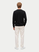 Rückansicht des schwarzen Pullovers am Modell mit glattem Strick und gerader Passform