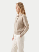 Seitenansicht am Model: naturbeiger Polopullover mit lockerer Passform zu cremefarbener Hose