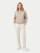 Frontansicht am Model: naturbeiger Polopullover aus Kaschmir zu cremefarbener Hose und weißen Sneakern