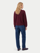 Rückansicht am Model: weinrote Kaschmir-Strickjacke zu blauer Jeans und dunklen Loafern