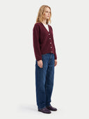 Seitenansicht am Model: weinrote Strickjacke mit Knopfleiste über weißem Top zu blauer Jeans