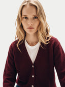 Nahaufnahme am Model: weinrote Kaschmir-Strickjacke mit V-Ausschnitt und Knopfleiste über weißem T-Shirt