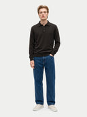 Model trägt den Polopullover in Olive Brown zu blauer Jeans und weißen Sneakern, Vorderansicht