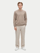 Modell trägt den taupefarbenen Pullover zu heller Hose, Ganzkörperansicht von vorne