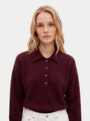 Nahaufnahme am Model: weinroter Kaschmir-Polopullover mit Knopfleiste zu weißer Hose