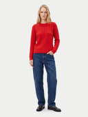 Model trägt den Strickpullover in Hibiscus zu blauer Jeans, Ganzkörperansicht von vorne