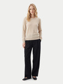Kaschmirpullover mit Rundhalsausschnitt in Beige, von einem Model mit schwarzer Hose getragen, Vorderansicht